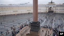 People gather to honor 224 victims killed in Saturday's plane crash over Egypt, at the foot of the Alexander Column at Dvortsovaya Square in St. Petersburg, Russia, Nov. 4, 2015.