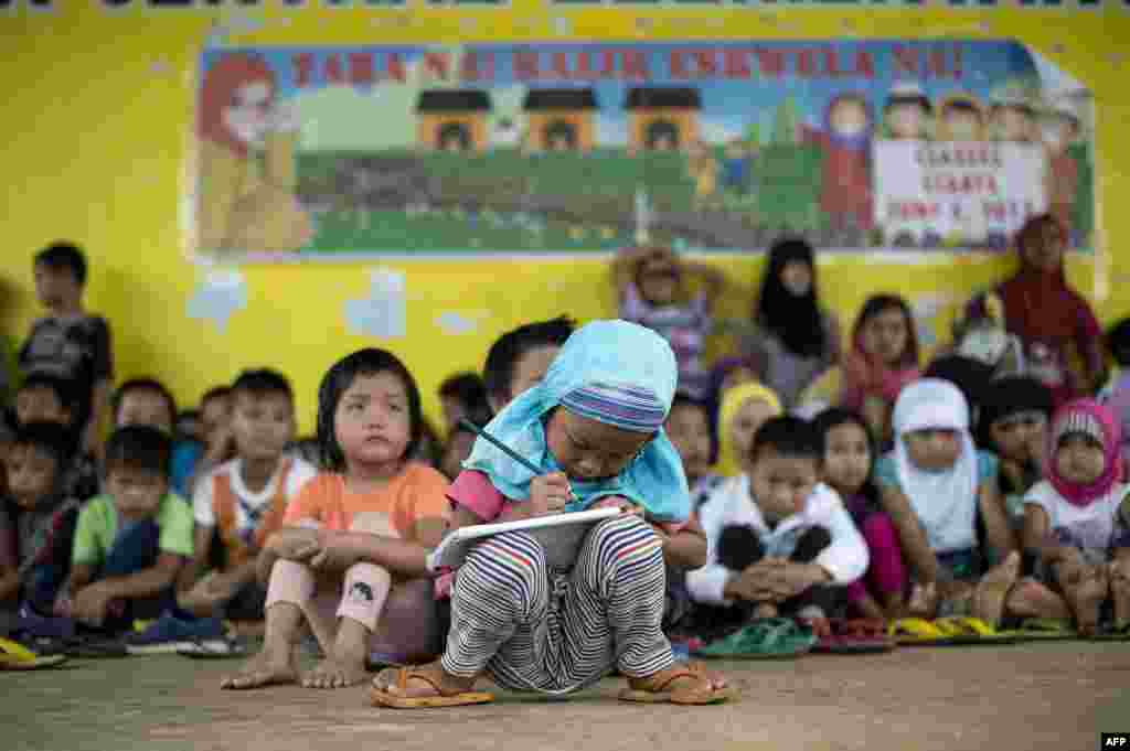 Anak-anak muslim Filipina belajar di kelas darurat di kota Pantar, Lanao del Norte di Pulau Mindanao, Filipina. Sekitar 238 anak sekolah mengungsi bersama orangtua mereka dari Marawi yang dilanda pertempuran ke kota Pantar dengan berjalan kaki selama 8 jam.