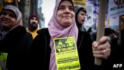 FILE - A Muslim woman holds a poster during a protest against Donald Trump in New York, Dec. 20, 2015.