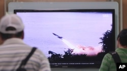 FILE - People watch a TV news program showing the missile launch conducted by North Korea, at Seoul Railway Station in Seoul, South Korea, June 29, 2014. 
