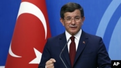 FILE - Then-Turkish Prime Minister Ahmet Davutoglu speaks to the media at the headquarters of the Justice and Development Party, AKP, in Ankara, Turkey, May 5, 2016.