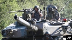 FILE - South Korean army soldiers ride a K-1 tank during the annual exercise in Paju, South Korea, near the border with North Korea, Aug. 22, 2016. 