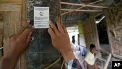 FILE - A census counter places a sticker at the entrance of a house after collecting information there, in Naypyitaw, Myanmar, on Oct. 1, 2024. The country is holding a national census to compile voter lists for a general election to be held in 2025.