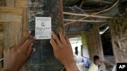 资料照片：2024年10月1日，缅甸内比都，一名人口普查员在收集信息后在一所房子的入口处贴上贴纸。缅甸正在举行全国人口普查，以汇编2025年大选的选民名单。