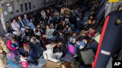 People sit in a German Bundeswehr airplane at the airport in Kabul, Afghanistan, Aug. 17, 2021, as the federal armed forces evacuates German citizens and local Afghans who worked for Germany. 