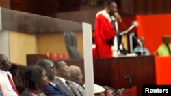 Simone Gbagbo, ancienne première dame ivoirienne et épouse de Larent Gbagbo, à l'extrême gauche, assise avec ses co-accusés au procès pour atteintes à la sureté de l'état à la cour d'assises d'Abidjan