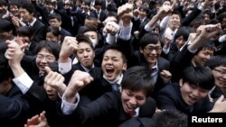 Japanese college students shout and raise their fists during a pep rally held to boost their morale ahead of their job hunt, at an outdoor theatre in Tokyo February 25, 2016. 