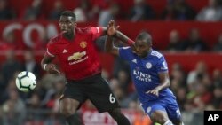 Pemain Manchester United, Paul Pogba (kri), mengincar bola dengan pemain Leicester City, Ricardo Pereira dalam laga Liga Utama Inggris antara Manchester United dan Leicester City di Old Trafford di Manchester, Inggris, 10 Agustus 2018.
