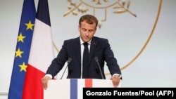 Le président français Emmanuel Macron prononce un discours lors d'une cérémonie à la mémoire des Harkis, des Algériens qui ont aidé l'armée française pendant la guerre d'indépendance algérienne, au palais de l'Élysée à Paris, le 20 septembre 2021.