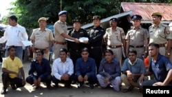 The seven Rohingya men to be deported sit as Indian and Myanmar security officials exchange documents before their deportation on India-Myanmar border at Moreh in the northeastern state of Manipur, India, Oct. 4, 2018.