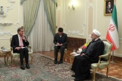 FILE - Pakistan's Foreign Minister Shah Mahmood Qureshi, left, and Iranian President Hassan Rouhani, meet in Tehran, Iran, Jan. 12, 2020, in this photo released by official website of the Office of the Iranian Presidency.