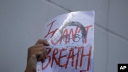 FILE - An activist holds up a picture of Thai dissident Wanchalerm Satsaksit during a rally in front of Cambodian Embassy in Bangkok, Thailand, June 8, 2020. 