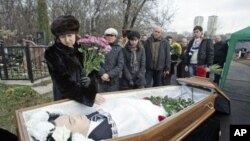 Nataliya Magnitskaya (L), mother of Sergei Magnitsky, grieves over her son's body during his funeral at a cemetery in Moscow November 20, 2009.