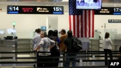 FILE - International travelers wait in line at a U.S. Customs and Border Protection checkpoint after arriving at Miami International Airport on March 4, 2015, in Miami, Florida.