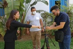 FILE - Al Jazeera journalists prepare to go live from the National Syndicat headquarters in the Tunisian capital, Tunis, July 26, 2021.