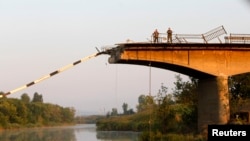 Ukrainian servicemen stand on bridge ruined during battles between the Ukrainian army and pro-Russian separatists on the outskirts of Slaviansk, Aug. 8, 2014.