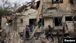 People check their family's damaged house at the scene where one of the projectiles fell, after they crossed over to Israel from Lebanon, amid ongoing hostilities between Hezbollah and Israel, in Rinatiya, Israel, Nov. 24, 2024.