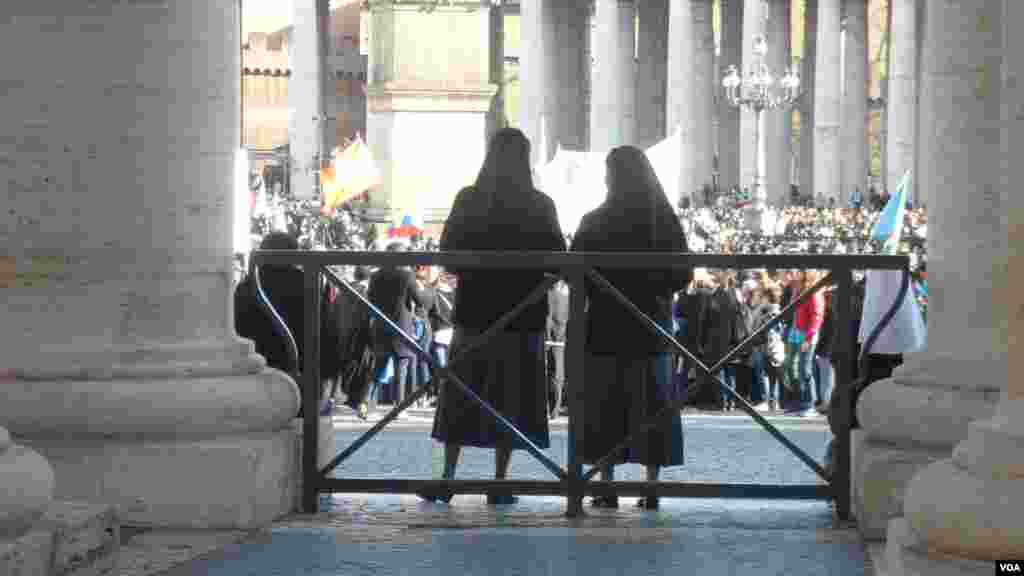 Two nuns watch the crowd at Saint Peter's Square for Pope Francis' inaugural mass at the Vatican, March 19, 2013. (A. Pessin/VOA)