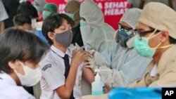 A student reacts as a medical worker administers a shot of the Sinovac COVID-19 vaccine during a vaccination campaign for children between 12-17 years of age at a school in Tangerang, Indonesia, Wednesday, July 14, 2021. The world's fourth most…
