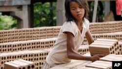 A Cambodian girl prepares bricks to dry under the sun light at a brick factory in Chheuteal village, Kandal province, some 27 kilometers (17 miles) north of Phnom Penh, Cambodia, file photo. 