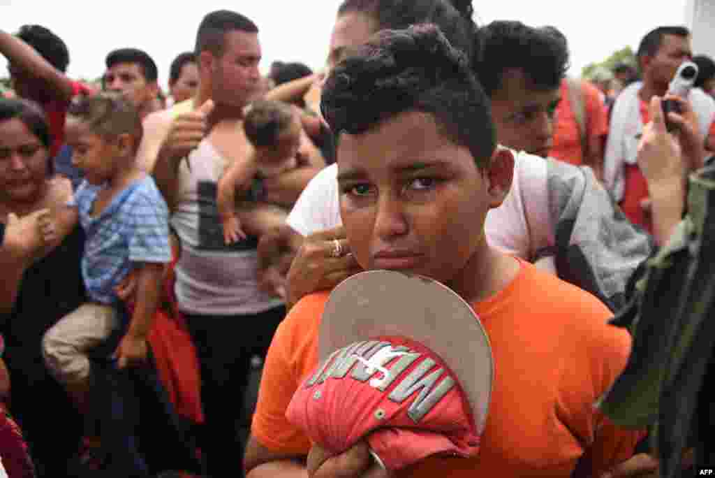 A Honduran migrant boy taking part in a caravan heading to the US, cries as he waits on the Guatemala-Mexico border bridge, in Ciudad Tecun Uman, Guatemala, on Oct. 20, 2018.
