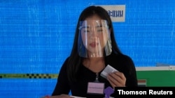 A woman wearing a face shield votes in the provincial election in Nonthaburi, Thailand, Dec. 20, 2020.