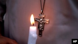 FILE - A Pakistani nun holds a candle during a vigil for victims of a deadly suicide bombing in a park, March 28, 2016, in Lahore.