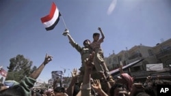 A Yemeni army officer is raised aloft by anti-government protesters during a demonstration demanding the resignation of Yemeni President Ali Abdullah Saleh, in Sana'a, April 4, 2011