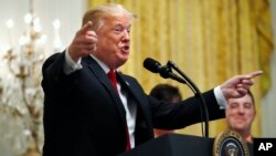 FILE - President Donald Trump gestures as he speaks about taxes, June 29, 2018, during an event in the East Room of the White House in Washington.