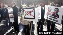LATVIA – Posters condemning Nazism and Communism at a rally in the Latvian capital. Riga, March 16, 2013