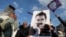 FILE - A demonstrator holds a picture of jailed Kurdish militant leader Abdullah Ocalan during a rally in Diyarbakir, Turkey, Feb. 27, 2025. The Peoples' Equality and Democracy Party has announced a new roadmap to peace following Ocalan's call for his group to disarm. 