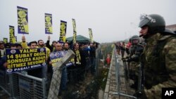 Paramilitary police stand as Fenerbahce fans shout slogans outside a Turkish court house in support of 93 suspects, including the club's jailed president Aziz Yildirim, ahead of the opening hearing of a match-fixing case in Silivri near Istanbul, Turkey, 