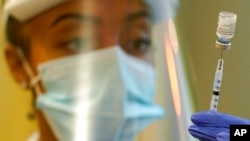 FILE - In this Jan. 8, 2021, photo, a pharmacist prepares a syringe of the Pfizer vaccine for COVID-19, at Queen Anne Healthcare, a skilled nursing and rehabilitation facility in Seattle.