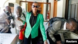 Kenyan marathon runner Rita Jeptoo walks past photographers as she arrives at the Athletics Kenya headquarters after failing a doping test, in Kenya's capital Nairobi, January 15, 2015.
