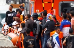 Migrants wait to disembark from a Spanish coast guard vessel in the port of Arguineguin, in the island of Gran Canaria, Spain, Sept. 1, 2021.