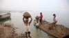 FILE - Laborers transport sand from boats to the shore after excavations from the bed of the River Yamuna in Allahabad, India, Nov. 19, 2011. Greater construction in India has led to a high demand for river sand, which leads to indiscriminate mining.