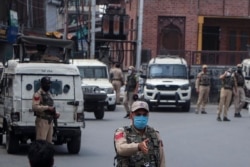 Indian policemen guard at a closed market during a strike by separatists on the second anniversary of India’s revocation of the disputed region’s semiautonomy in Srinagar, Indian-controlled Kashmir, Aug. 5, 2021.