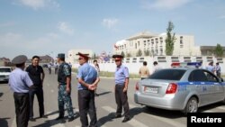 FILE - Investigators, interior ministry officers and members of security forces gather near the site of a bomb blast outside the Chinese Embassy in Bishkek, Kyrgyzstan, Aug. 30, 2016.