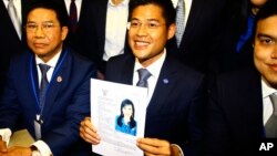 Leader of Thai Raksa Chart party Preecha Pholphongpanich, center, holds a picture of Princess Ubolratana at election commission of Thailand in Bangkok, Feb. 8, 2019. The political party has selected the princess as its nominee as the next prime minister.