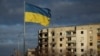 La bandera de Ucrania flota junto a edificios destrtruidos por ataques rusos en Borodianka, en la región de Kiev, el 15 de febrero de 2023.