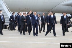 Mantan Presiden Taiwan Ma Ying-jeou (tengah) melambai kepada massa saat tiba di bandara di Shanghai, China Senin (27/3).