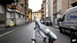 A staffer delivers a medical oxygen tank to coronavirus patients who are being treated at home, in Bergamo, one of the areas worst affected by the virus, Northern Italy, Tuesday, March 31, 2020. The new coronavirus causes mild or moderate symptoms…