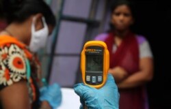 A health worker screens people for COVID-19 symptoms at Dharavi, one of India's biggest slums, in Mumbai, July 6, 2020.