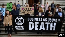 Climate change activists stage a protest outside the H M Treasury building in central London, April 25, 2019, during environmental protests by the Extinction Rebellion group.