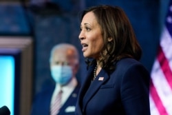President-elect Joe Biden listens as Vice President-elect Kamala Harris speaks about economic recovery at The Queen theater, in Wilmington, Delaware, Nov. 16, 2020.