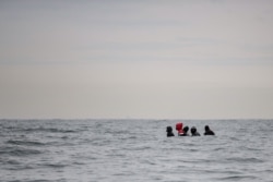 FILE - Migrants navigate a boat in agitated waters between Sangatte and Cap Blanc-Nez, in the English Channel off the coast of northern France, as they attempt to cross the maritime borders between France and the United Kingdom, Aug. 27, 2020.