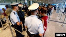 FILE - Police officers are seen patrolling at a security gate inside the main terminal of Frankfurt Airport.