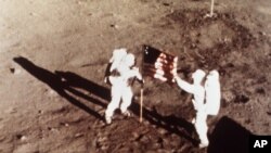 FILE - Apollo 11 astronauts Neil Armstrong and Edwin E. "Buzz" Aldrin, the first men to land on the moon, plant the U.S. flag on the lunar surface, July 20, 1969. (NASA)