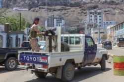 FILE - A fighter with Yemen's separatist Southern Transitional Council (STC) mans a gun in the back of a vehicle deploying in the southern city of Aden, April 26, 2020.