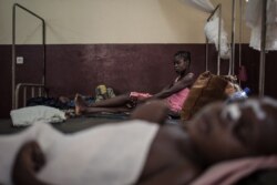 FILE - A mother watches her HIV-positive child in the intensive care unit of the Bangui pediatric complex, while in the foreground, an HIV-positive child sleeps, in Central African Republic, Dec. 4, 2018.